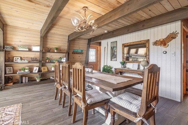 dining room featuring wooden ceiling, beamed ceiling, wood finished floors, and a chandelier