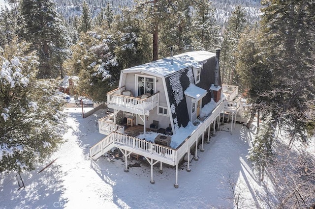 snowy aerial view featuring a forest view