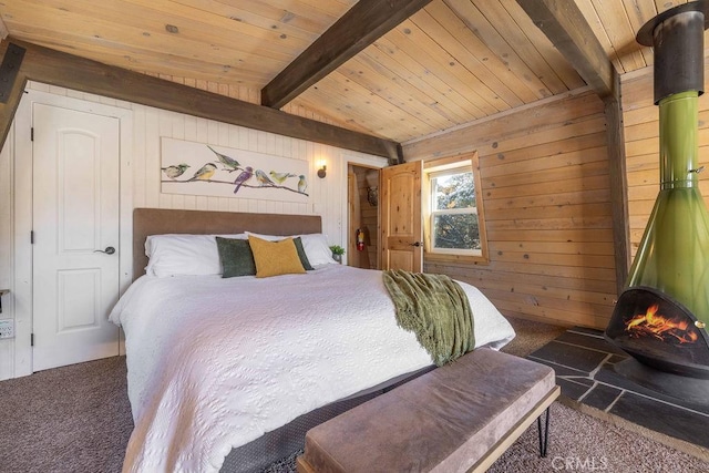 carpeted bedroom featuring beam ceiling, wooden walls, wood ceiling, and a wood stove