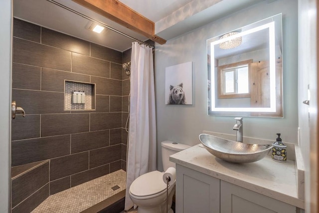 full bathroom with vanity, toilet, and a tile shower