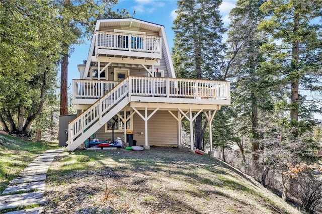 back of property featuring stairs and a deck