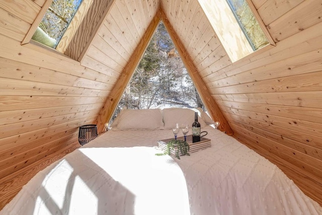 bedroom featuring vaulted ceiling with skylight, wood walls, and wooden ceiling