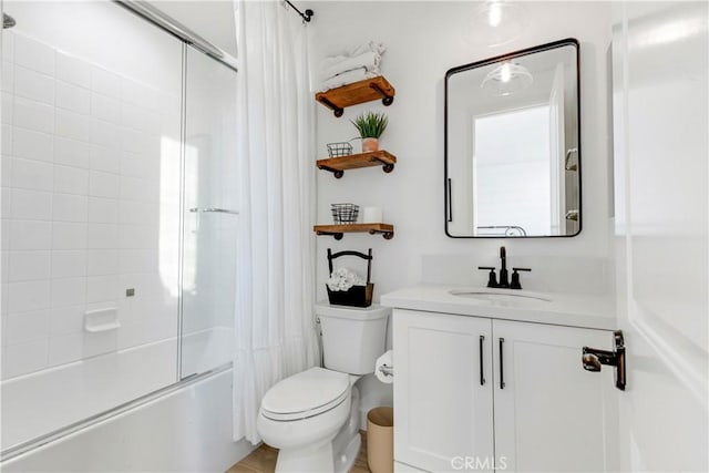 full bath with vanity, toilet, and combined bath / shower with glass door