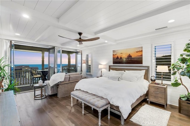 bedroom with visible vents, beamed ceiling, access to exterior, wood finished floors, and ceiling fan