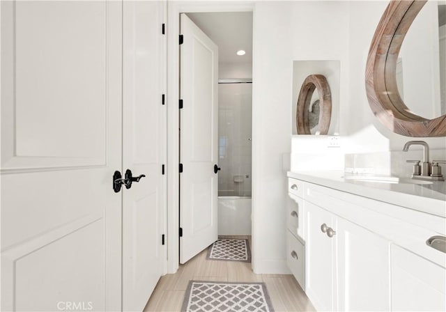 bathroom featuring recessed lighting, vanity, and shower / bath combination with glass door