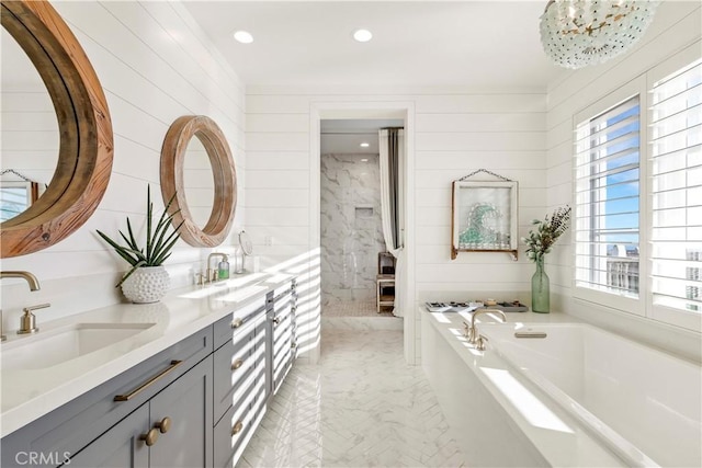 full bath featuring double vanity, recessed lighting, a garden tub, and a sink