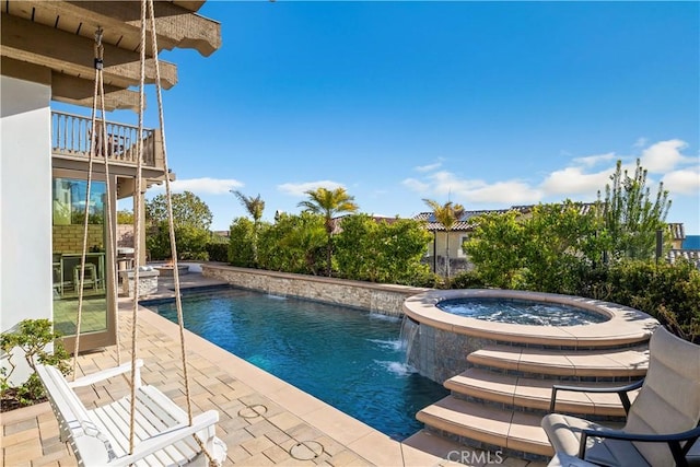 outdoor pool featuring a patio area and an in ground hot tub