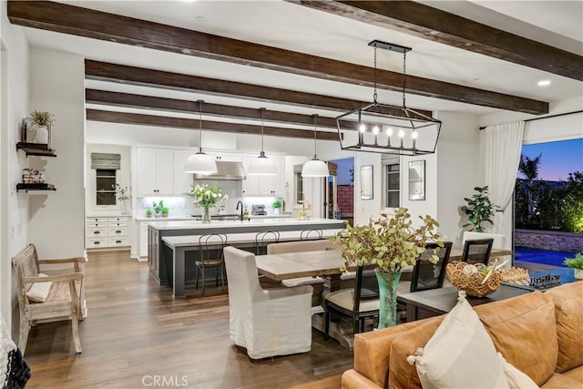 dining area with beam ceiling and dark wood finished floors