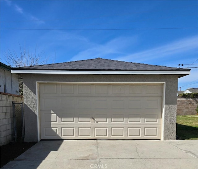 garage with driveway and fence