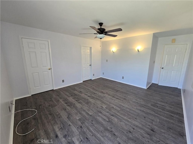 unfurnished room featuring baseboards, dark wood-type flooring, and ceiling fan