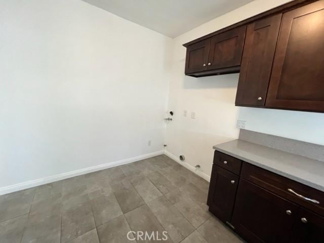 laundry room featuring hookup for a washing machine, cabinet space, and baseboards