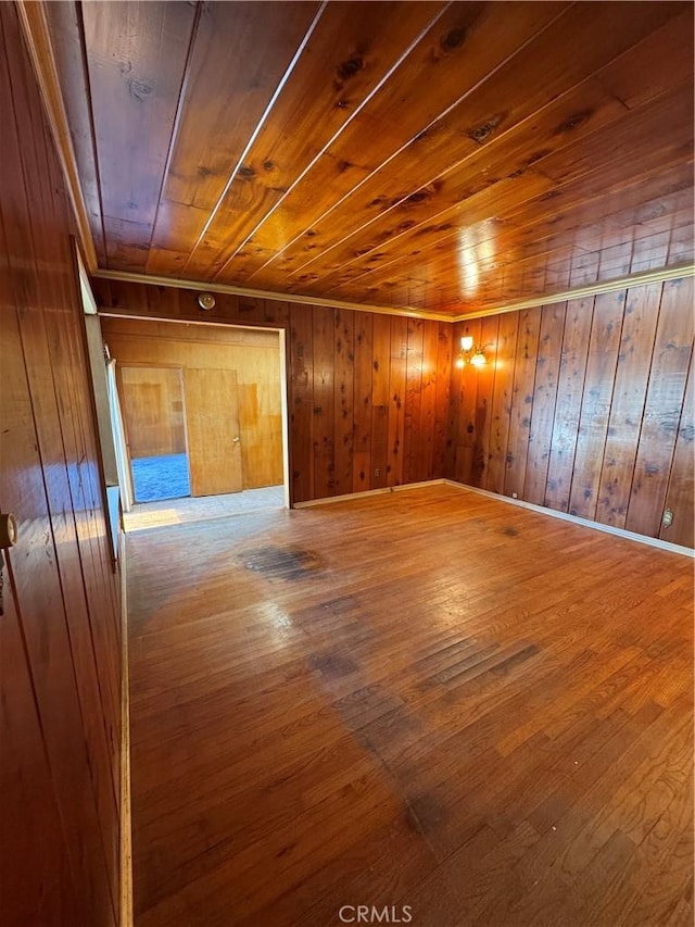 interior space featuring wooden walls, wood ceiling, and wood finished floors