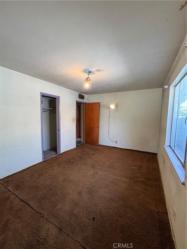 unfurnished bedroom featuring carpet and visible vents