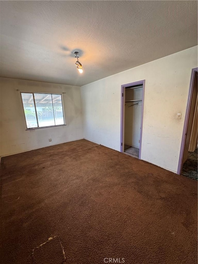 unfurnished bedroom featuring carpet, a closet, and a textured ceiling