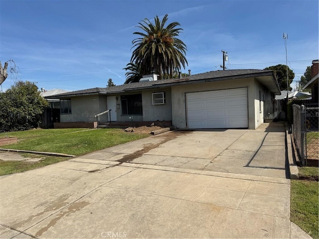 ranch-style house with fence, concrete driveway, a front yard, stucco siding, and a garage