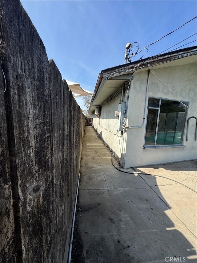 view of property exterior with a patio area, stucco siding, and a fenced backyard