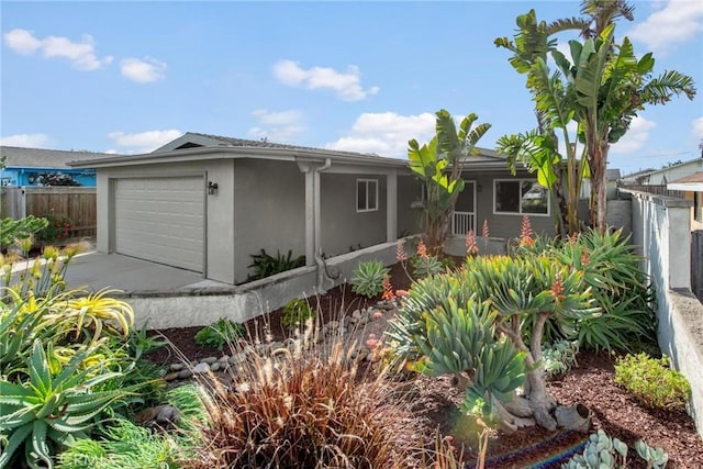 view of front of home featuring stucco siding and fence