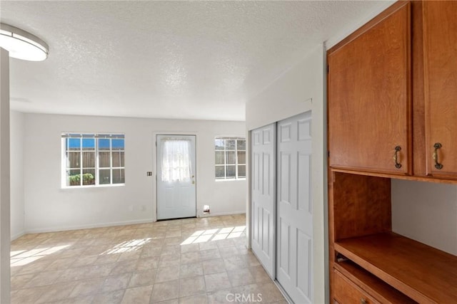 entryway featuring baseboards and a textured ceiling