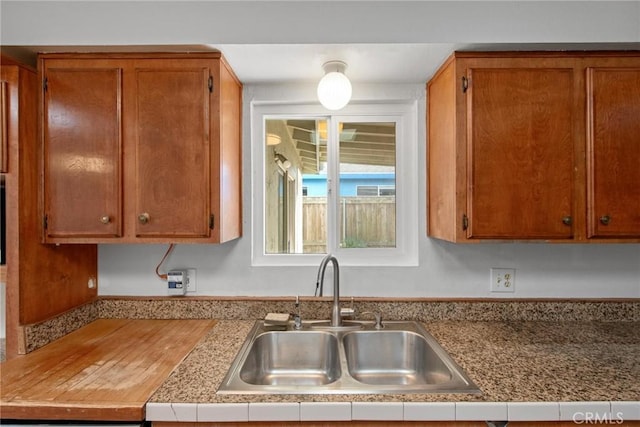 kitchen with brown cabinets, light countertops, and a sink