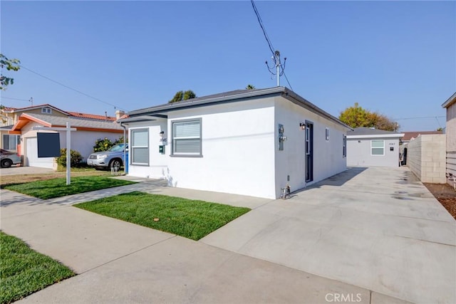 view of front of house with stucco siding and a front lawn