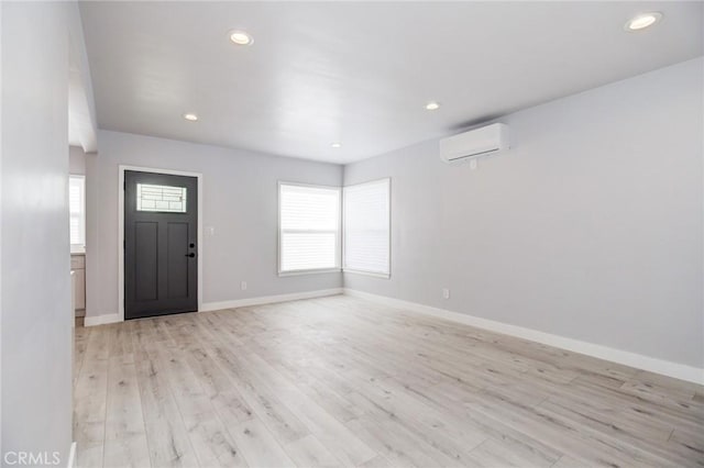 foyer with light wood finished floors, recessed lighting, baseboards, and a wall unit AC