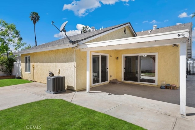 back of property with a patio, central AC unit, fence, a yard, and stucco siding