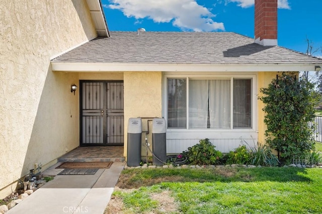 doorway to property featuring stucco siding, a chimney, and a shingled roof