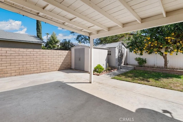 view of patio with a storage unit, an outdoor structure, and a fenced backyard