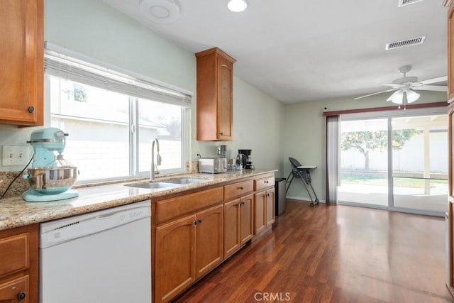 kitchen featuring visible vents, white dishwasher, dark wood-style flooring, ceiling fan, and a sink