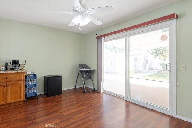 interior space with baseboards, dark wood finished floors, and a ceiling fan