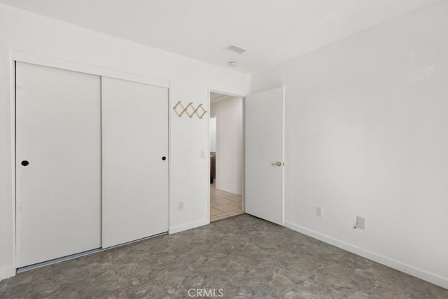 unfurnished bedroom featuring baseboards and a closet