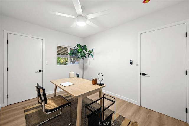 office space with light wood-style flooring, baseboards, and a ceiling fan