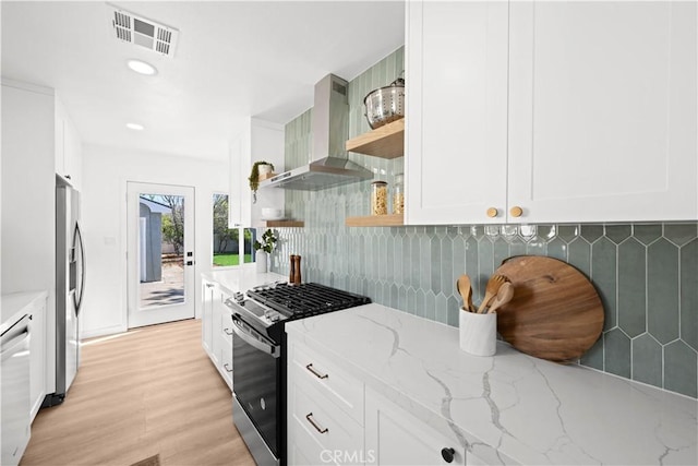 kitchen with visible vents, open shelves, white cabinets, appliances with stainless steel finishes, and wall chimney range hood