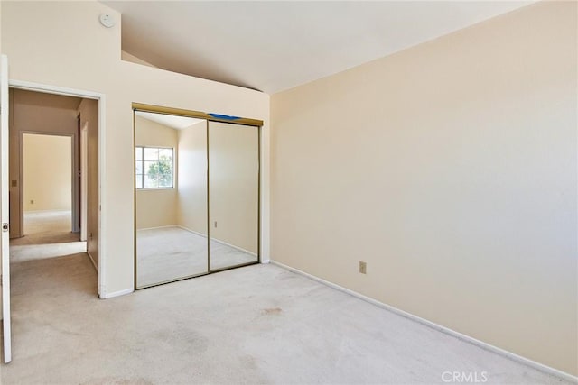 unfurnished bedroom featuring light colored carpet, a closet, and baseboards