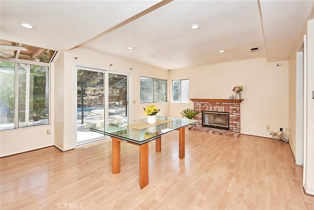 dining space with a fireplace, recessed lighting, light wood-style floors, and visible vents