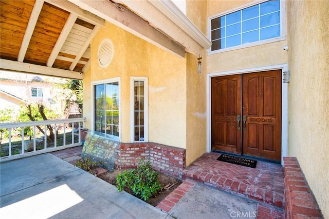 entrance to property featuring brick siding and stucco siding