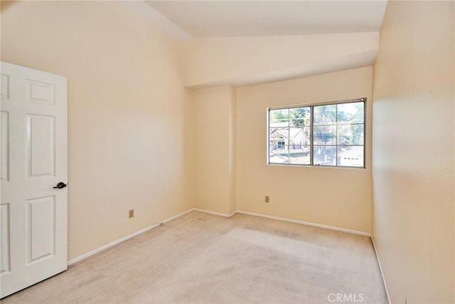 spare room featuring vaulted ceiling, baseboards, and carpet floors