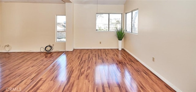 unfurnished room with baseboards and wood finished floors