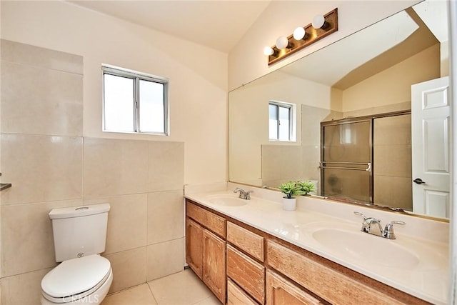 bathroom featuring tile patterned floors, a stall shower, toilet, and a sink