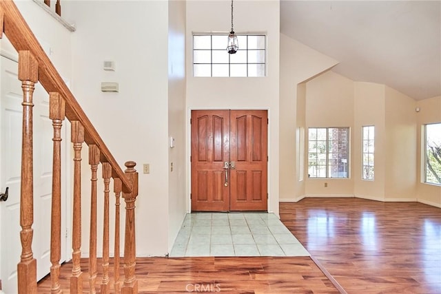 entryway featuring light wood finished floors, plenty of natural light, and stairs