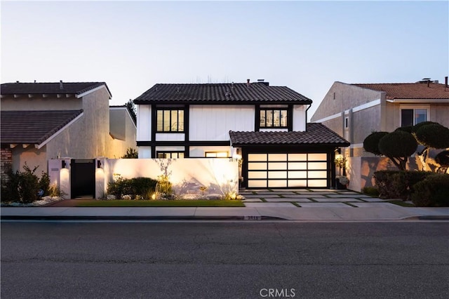 view of front of home with a garage, concrete driveway, and a tiled roof