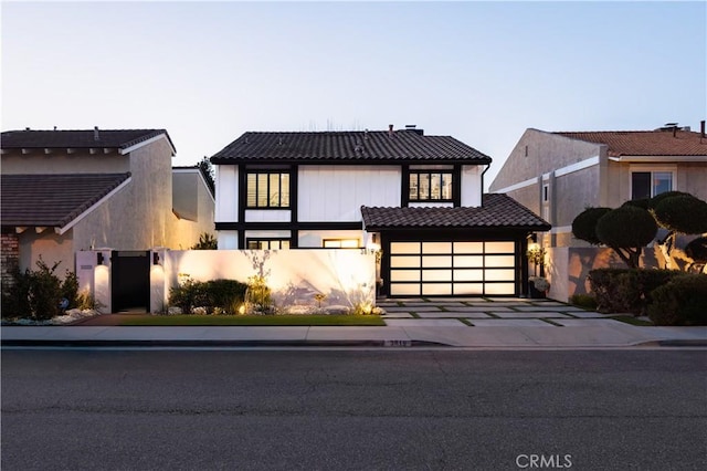 view of front of home with a tiled roof, stucco siding, and concrete driveway