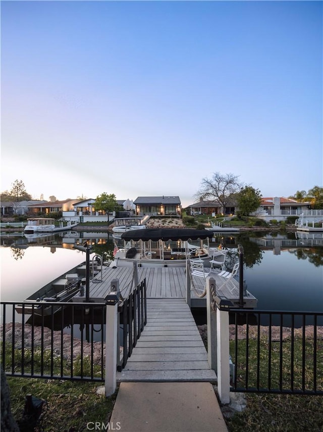 view of dock featuring a water view and a residential view