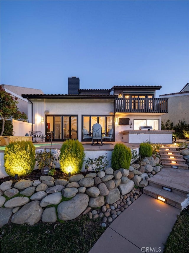 rear view of property with a patio area, central air condition unit, stucco siding, and a chimney