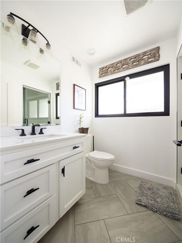 bathroom with visible vents, baseboards, toilet, and vanity