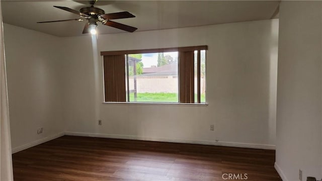 empty room with a ceiling fan, baseboards, and wood finished floors