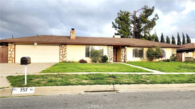 single story home with a garage, concrete driveway, a front lawn, and stone siding