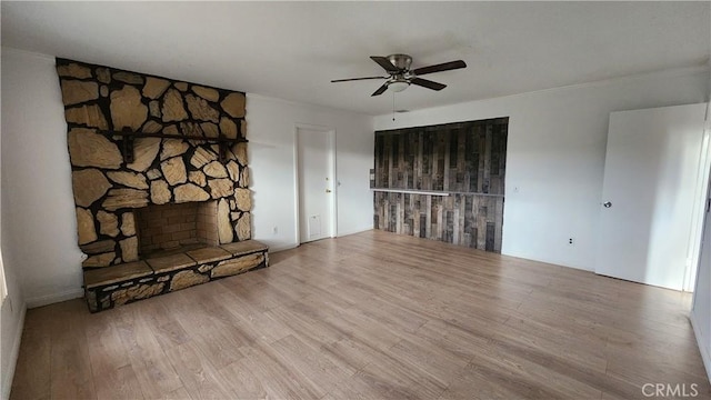 unfurnished living room with a fireplace, ceiling fan, and wood finished floors