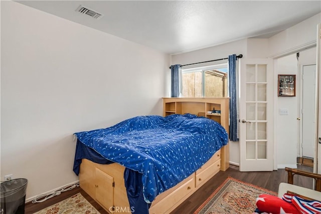 bedroom featuring visible vents and wood finished floors