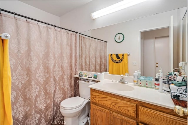 bathroom with vanity, curtained shower, and toilet